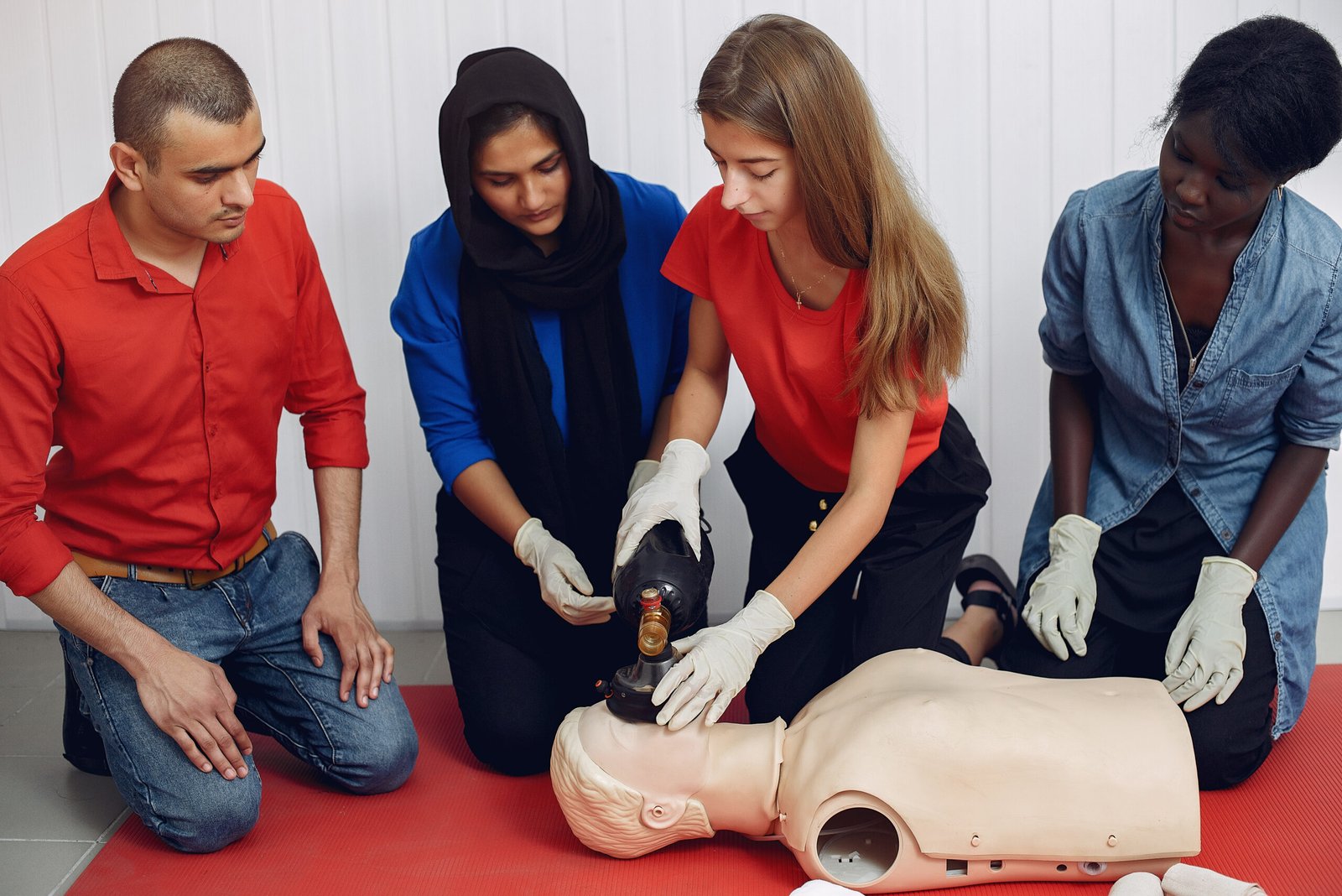 People are practicing medicine.Men and women are learning how to properly provide first aid.